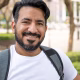 retrato-hombre-latino-barba-sonriendo-camara-llevando-mochila_665346-5872